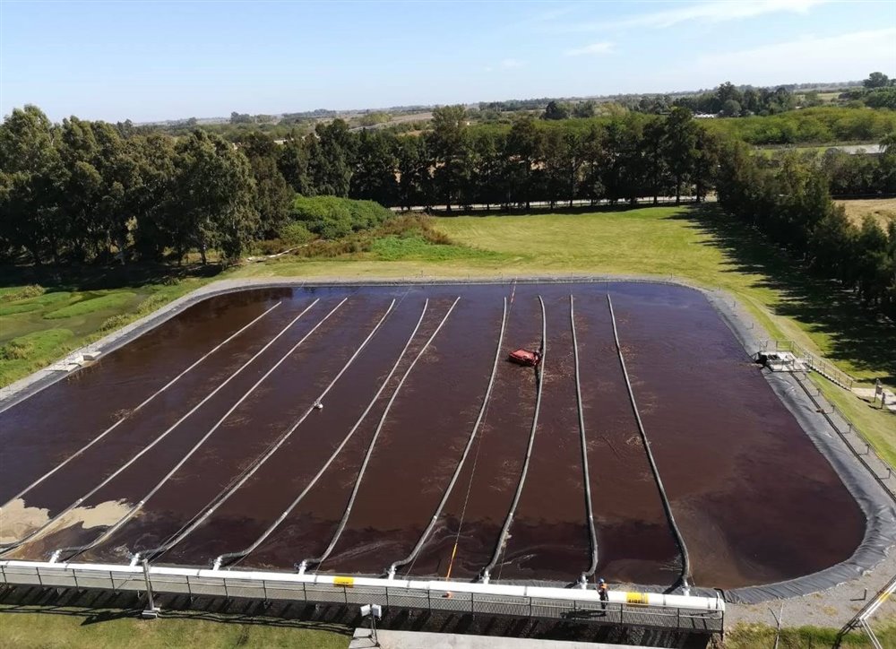 Vista aérea de una laguna aeróbica con las mangueras de aireación sobre el espejo de agua