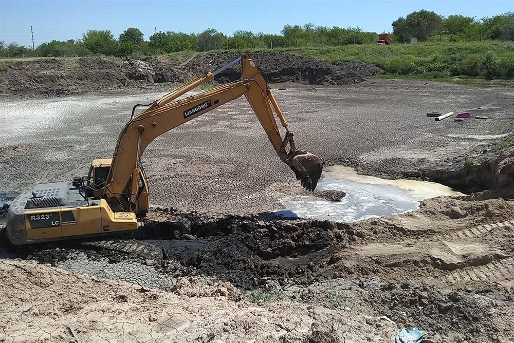 Retroexcavadora trabajando en el movimiento de suelos de una laguna aeróbica